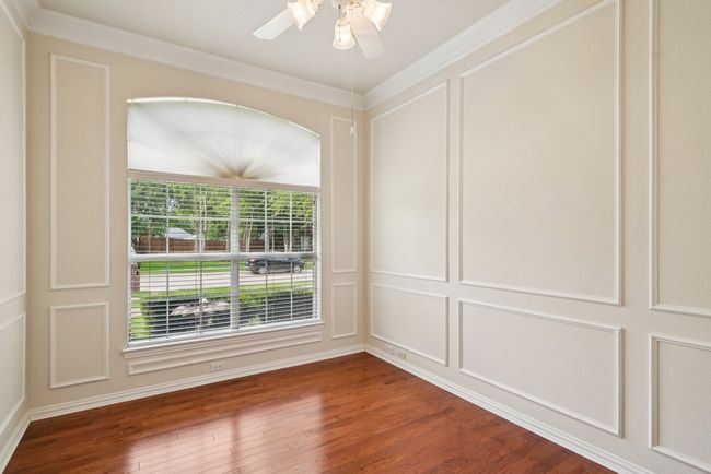 Spare room with a decorative wall, wood finished floors, and ornamental molding | Image 10