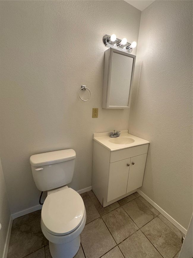 Half bathroom with vanity, toilet, tile patterned floors, and baseboards | Image 23