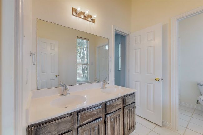 Bathroom with tile patterned floors, toilet, and double vanity | Image 28