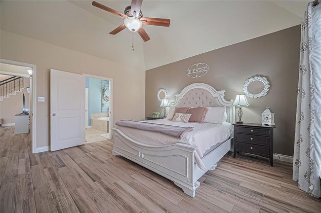 This spacious primary bedroom easily fits a king-size set and features a tasteful accent wall alongside a private ensuite bath for ultimate convenience. | Image 22