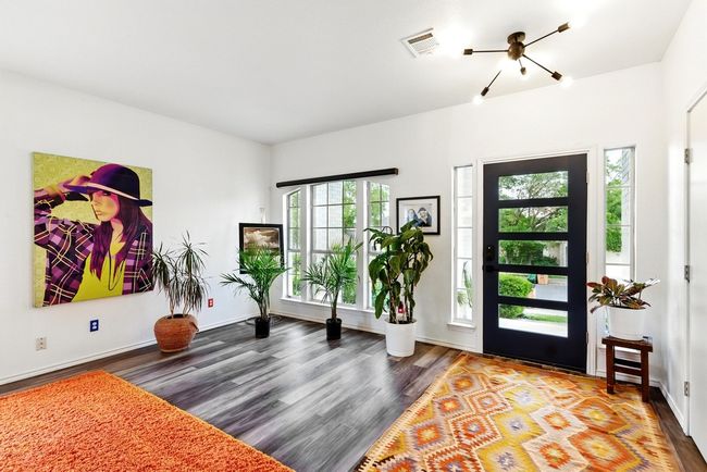 Dining room featuring visible vents, arched walkways, wood finished floors, and a healthy amount of sunlight | Image 4