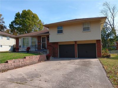 Split-level home featuring a front lawn and a garage | Image 1