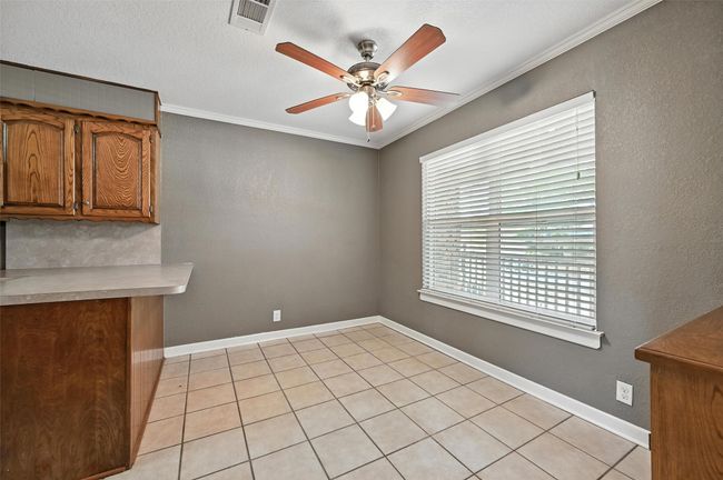 Unfurnished bedroom with wood finished floors, crown molding, a closet, and a ceiling fan | Image 11