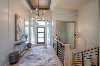 Former model Foyer entrance with a high ceiling, a raised ceiling, and a notable chandelier | Image 3