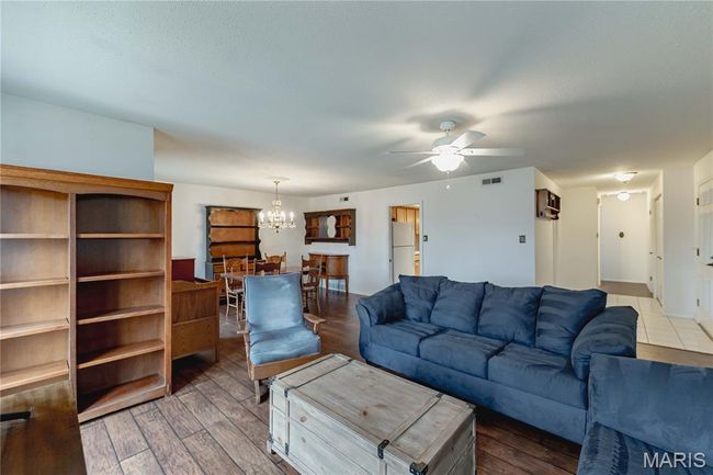 Living room with a chandelier, ceiling fan, and wood finished floors | Image 12