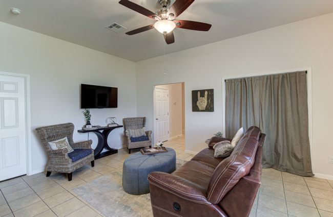 Living room featuring light tile patterned floors, a ceiling fan, and baseboards | Image 7