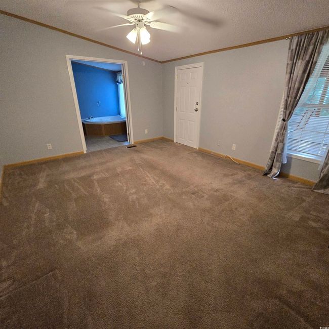 Master Bedroom with crown molding, a ceiling fan, carpet floors, and a textured ceiling | Image 22