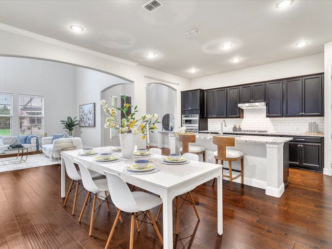 Dining area featuring ornamental molding, arched walkways, dark wood-type flooring, and recessed lighting | Image 8