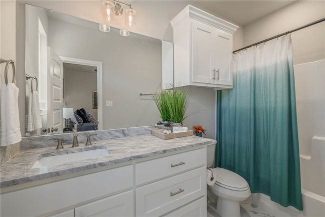 Bathroom featuring vanity and shower / bathtub combination with curtain | Image 19