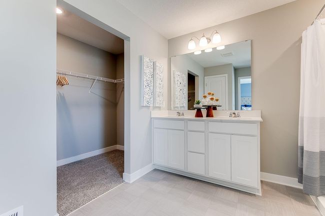 An extension of the primary suite, this private & spacious bathroom contains a double-vanity, a stand-in shower & access to a large walk-in closet!! Photo of model home, color & options may vary. | Image 17