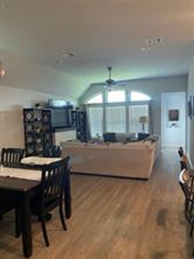 Dining area featuring a ceiling fan, wood finished floors, and vaulted ceiling | Image 5