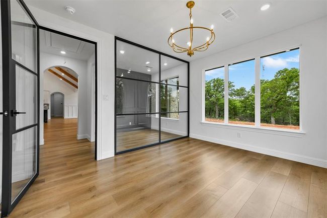 Empty room featuring a notable chandelier and light hardwood / wood-style floors | Image 23