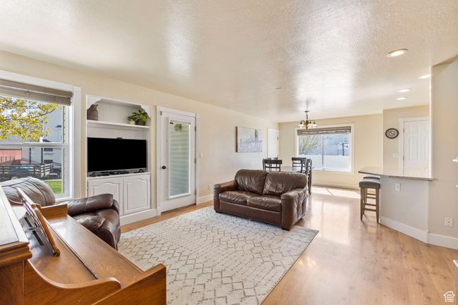 Living room featuring a textured ceiling, baseboards, recessed lighting, and light wood-style floors | Image 14