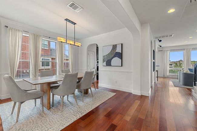 Dining space featuring dark wood-type flooring, recessed lighting, arched walkways, and ornamental molding | Image 8