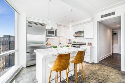 Chef's kitchen with island and Viking stainless steel appliances. | Image 3