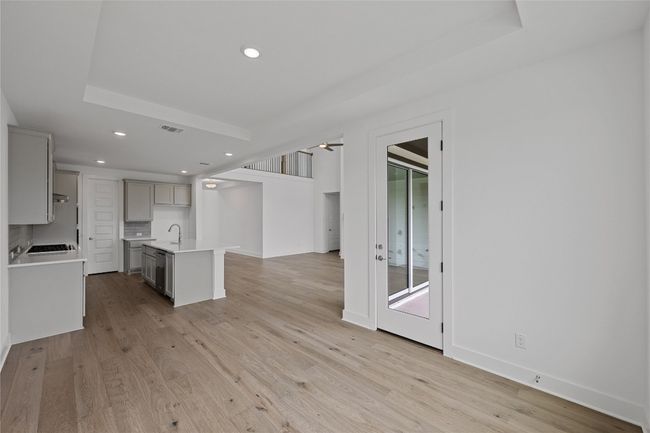 Kitchen featuring gray cabinets, recessed lighting, light countertops, a kitchen island with sink, and light wood-style flooring | Image 12