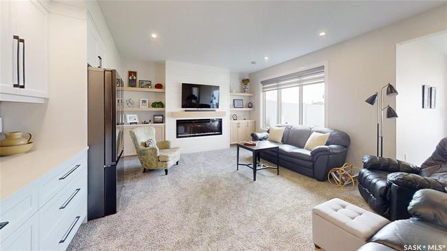 Living area featuring light colored carpet, a large fireplace, recessed lighting, and built in shelves | Image 24