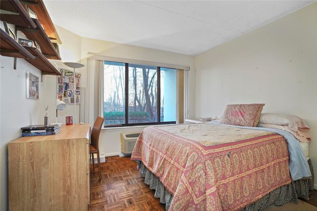 Bedroom with dark parquet flooring and a wall mounted air conditioner | Image 17