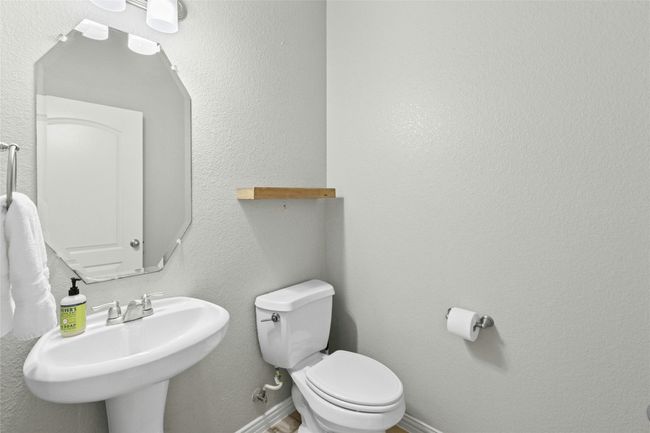 Half bath with a sink, toilet, and baseboards | Image 13