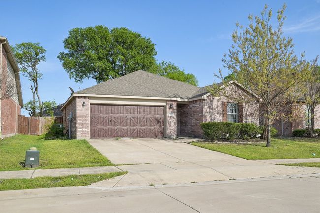 Single story home featuring driveway, brick siding, a front lawn, and an attached garage | Image 4