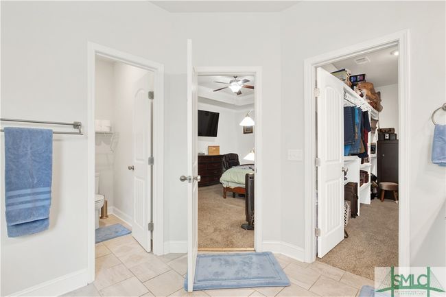 private Water closet, large walk-in closet with custom wood shelving | Image 22