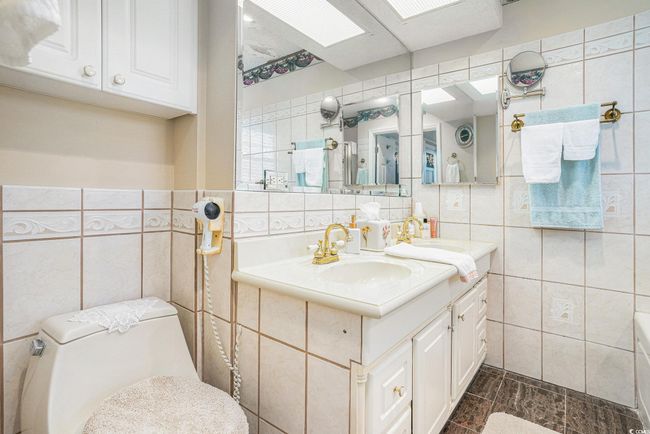 Bathroom featuring tile walls, vanity, and toilet | Image 25