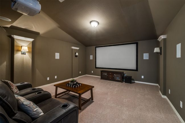 The home theater room boasts light carpet, a vaulted ceiling, upgraded light sconces, and built-in surround sound, creating the perfect cinematic experience. | Image 28