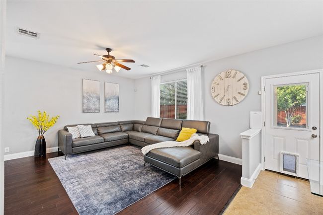 Living room with a ceiling fan and wood finished floors | Image 6