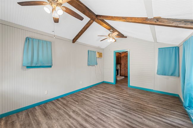 Unfurnished room featuring ceiling fan, wood finished floors, and wood walls | Image 27