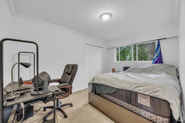 Bedroom featuring a closet, ornamental molding, carpet, a textured ceiling, and an office area | Image 18