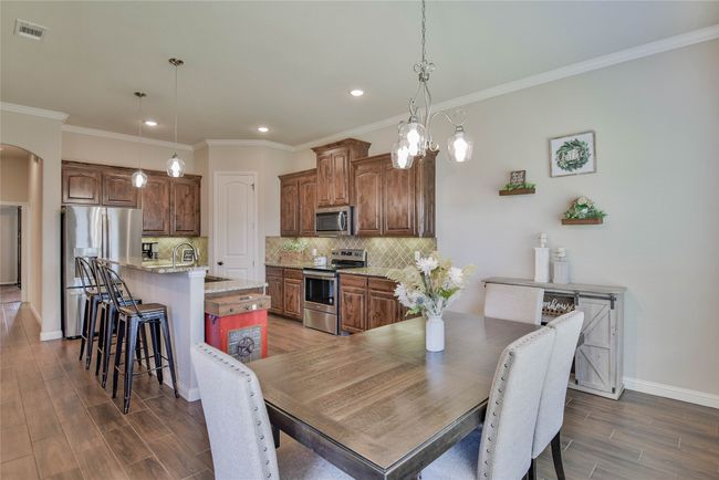 Dining room with dark wood finished floors, arched walkways recessed lighting, and baseboards | Image 15