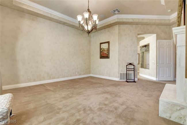 Carpeted empty room with crown molding, an inviting chandelier, visible vents, and baseboards | Image 28