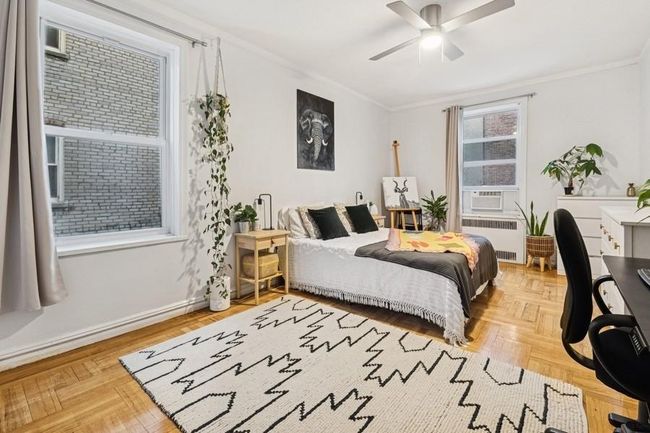 Bedroom featuring crown molding, baseboards, radiator, and ceiling fan | Image 11