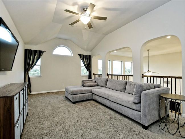 Living room featuring a ceiling fan, carpet flooring, arched walkways, and lofted ceiling | Image 25