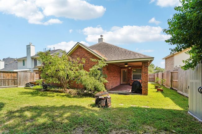 Charming brick home with a covered patio, perfect for outdoor entertaining. The backyard is fenced, providing privacy and a safe space for relaxation or gardening. | Image 28