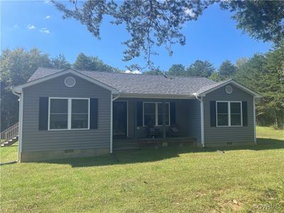 View of property exterior featuring an outbuilding, a yard, and a garage | Image 1