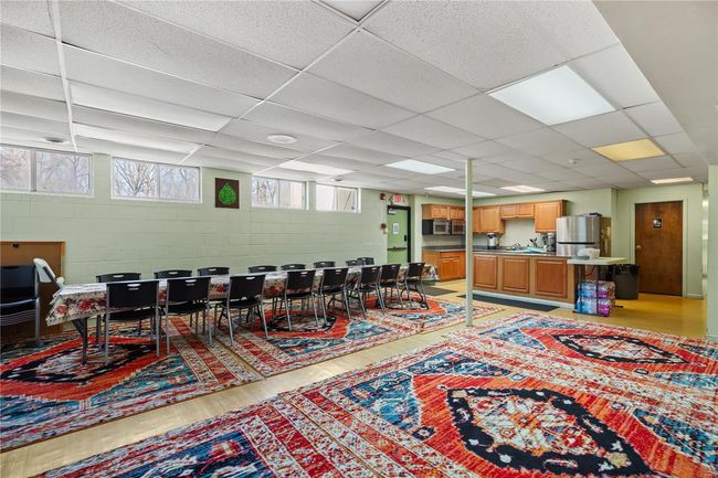Dining area featuring concrete block wall, light wood-type flooring, and a drop ceiling | Image 17