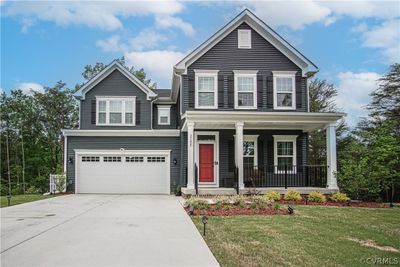 View of front of home with a front lawn, covered porch, and a garage | Image 1