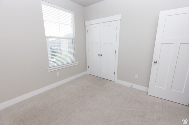 Unfurnished bedroom featuring carpet floors, baseboards, and a closet | Image 19