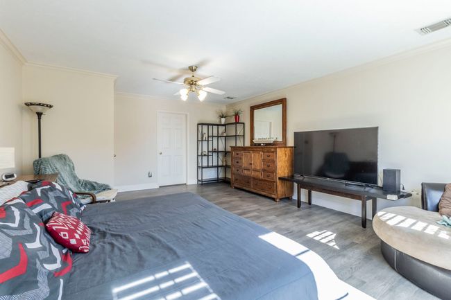 Bedroom featuring wood finished floors, ornamental molding, baseboards, and a ceiling fan | Image 12