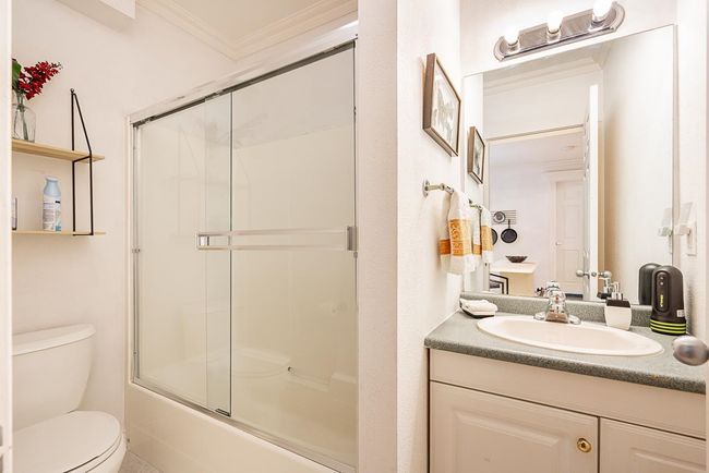 Bathroom with ornamental molding, vanity, and bath / shower combo with glass door | Image 31