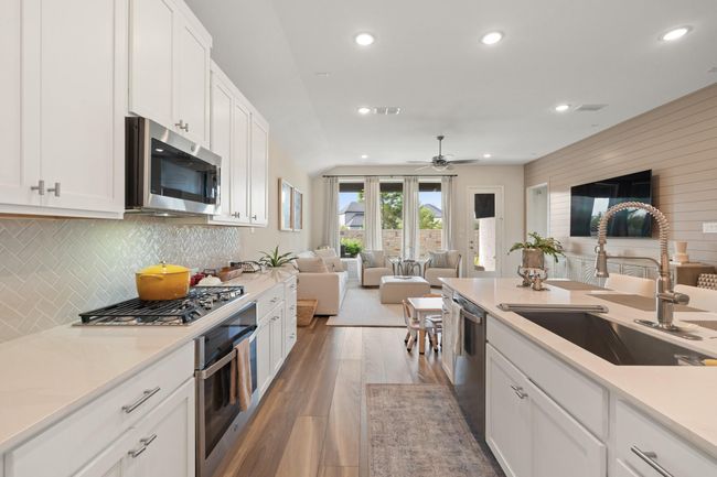 The cook's kitchen has a walk-in pantry, quartz countertops and luxury vinyl flooring. | Image 7