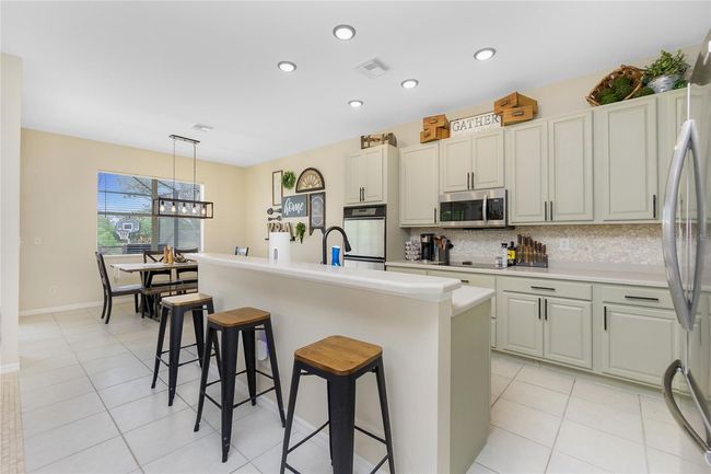 Kitchen open to Dining Room with Breakfast Bar at Island | Image 17