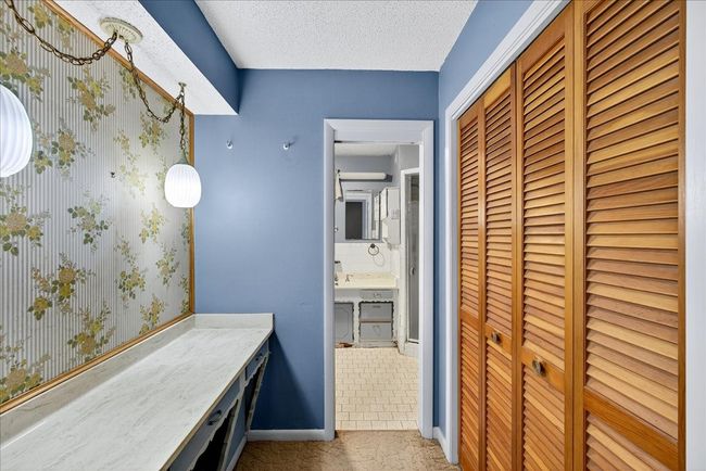 Bathroom with a closet, a textured ceiling, and vanity | Image 24