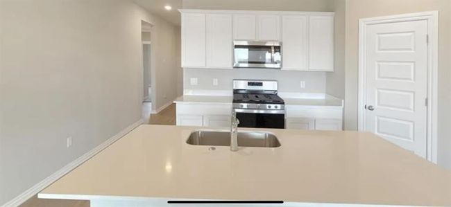 Kitchen with white cabinetry, appliances with stainless steel finishes, light countertops, and a sink | Image 5