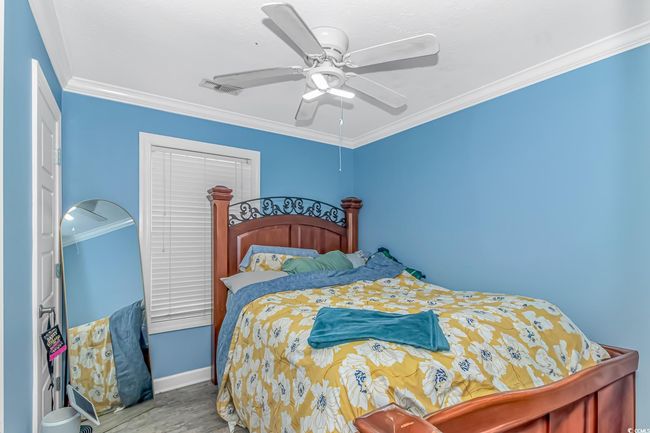 Bedroom with wood finished floors, crown molding, ceiling fan, and baseboards | Image 12