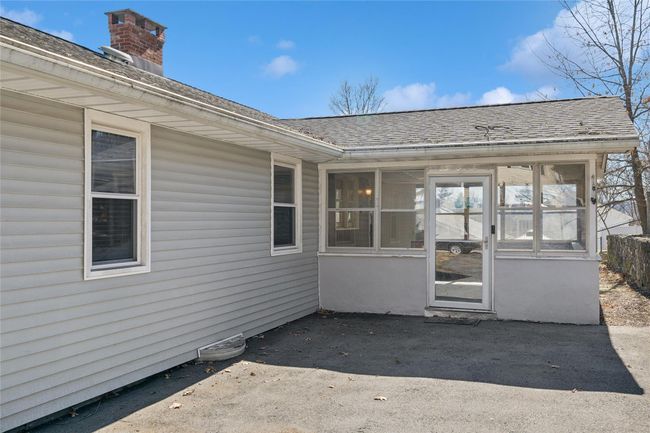View of exterior entry featuring a patio and roof with shingles | Image 7