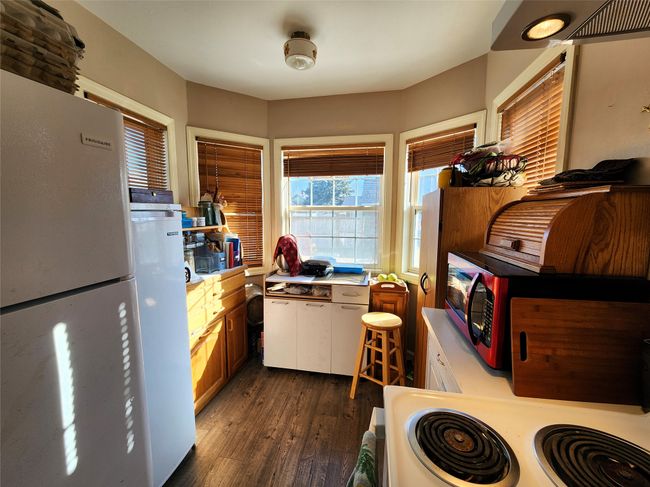 Kitchen featuring white cabinets, light countertops, dark wood-style floors, and white appliances | Image 21