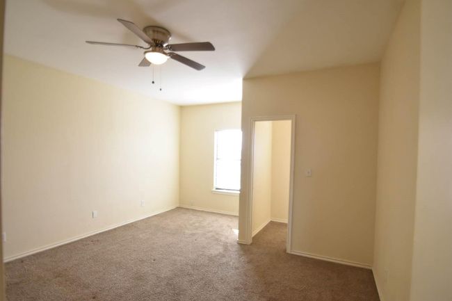 Carpeted spare room with baseboards and a ceiling fan | Image 5