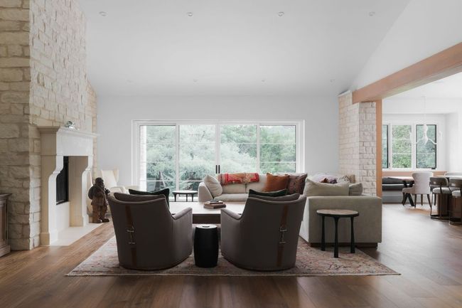 Living room with lofted ceiling, a large fireplace, healthy amount of natural light, and wood-type flooring | Image 11